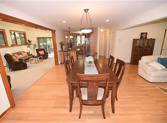 Dining area view toward kitchen, hallway leads to half bath and office/den.