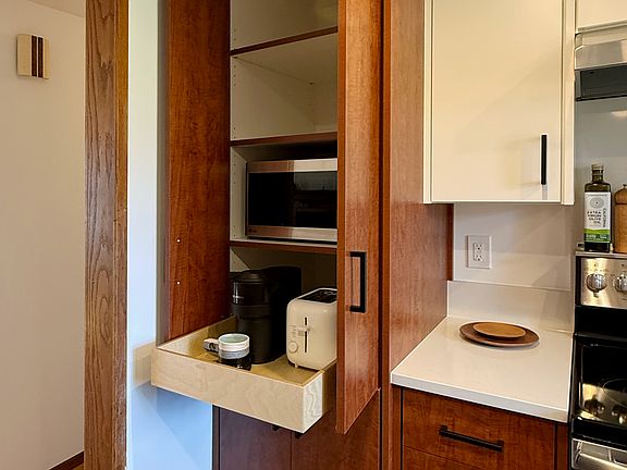 Kitchen appliance storage in pantry with outlet. Microwave included with rental.