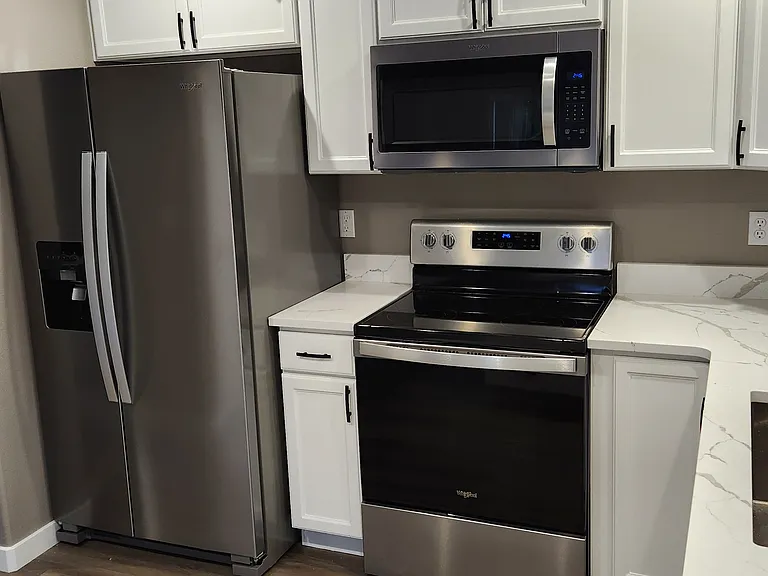 Kitchen with stainless-steel appliances & quartz counter tops.