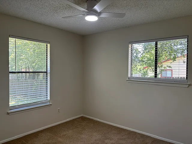 Back right bedroom looking out exterior windows at side and rear yard areas.