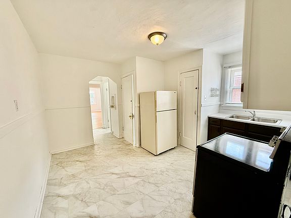 Kitchen area w/ room for a dining table & fresh paint, stainless steel stove, freshly painted cabinets & spacious pantry