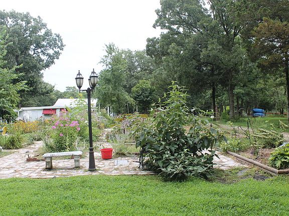Garden with outbuildings in background