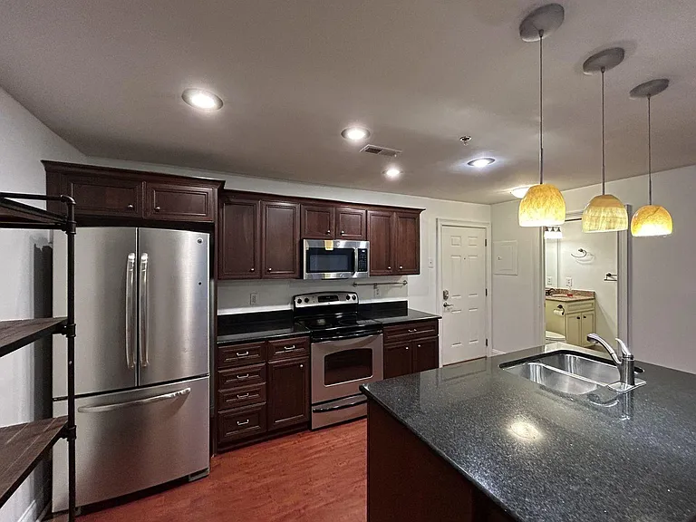 Spacious, open-concept kitchen featuring a large center island perfect for cooking, dining, or entertaining, plus extra built-in shelving for additional storage and display.