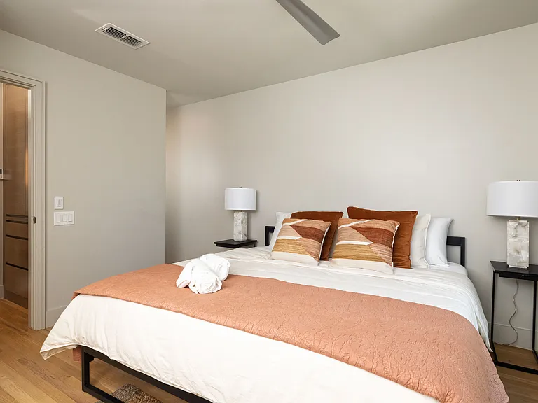 Primary bedroom with king bed, attached bathroom and ceiling fan.