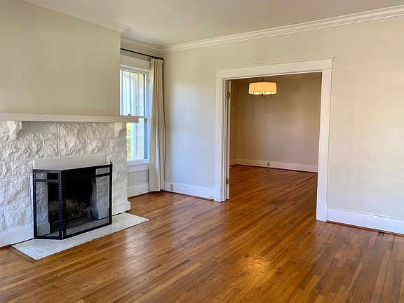 Living room with view into large dining room