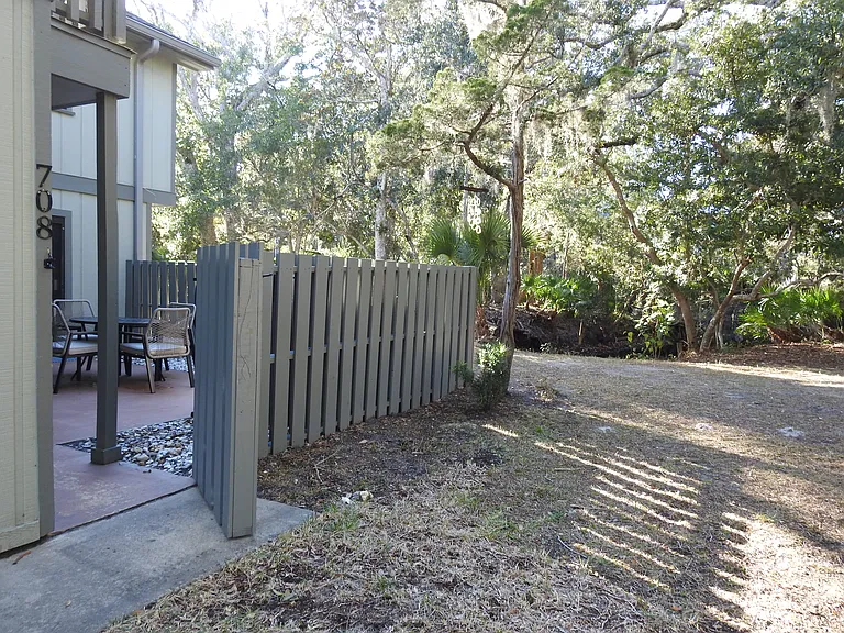 Front gate entrance with view of woods surrounding the property