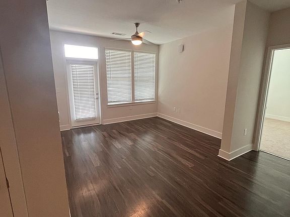 Kitchen opens up to living room with ceiling fan and 9' ceilings. Plenty of natural light