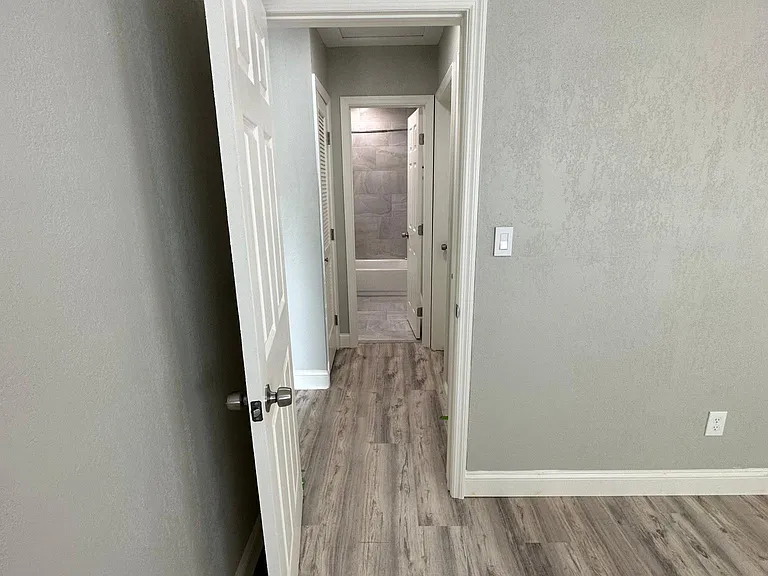 Bedroom 1; looking through the hallway into the bathroom.