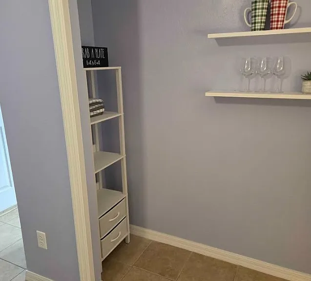 Private refreshment and storage area featuring hanging shelves for cups or decor, plus additional storage space with hand towels and to add your everyday essentials.