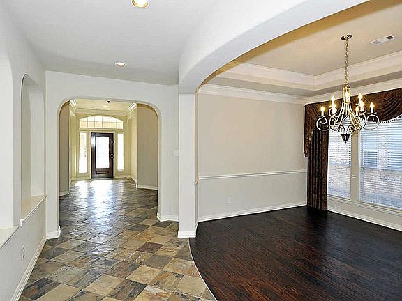 Dining with coffered ceiling, triple crown moulding, wood floor, & chair rail.