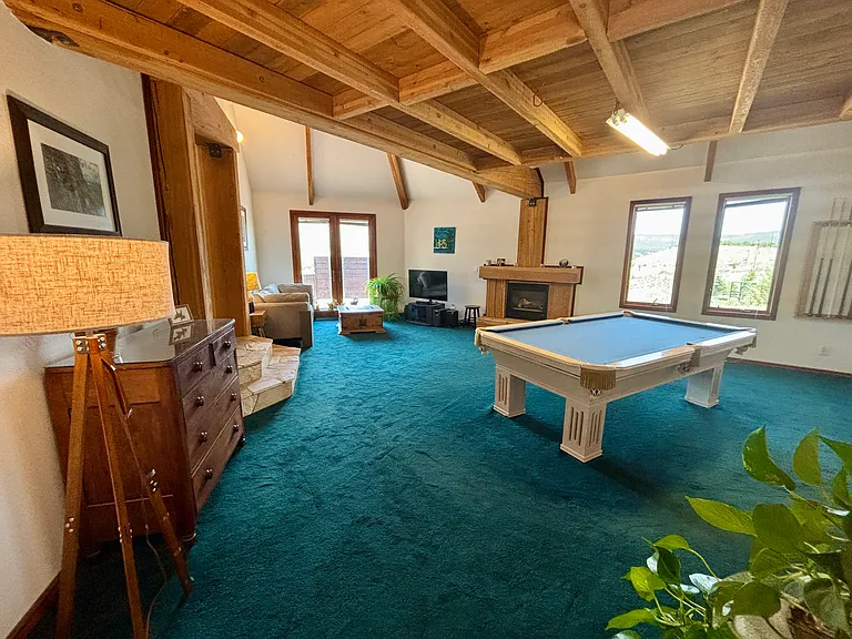 Game room with loft above pool table