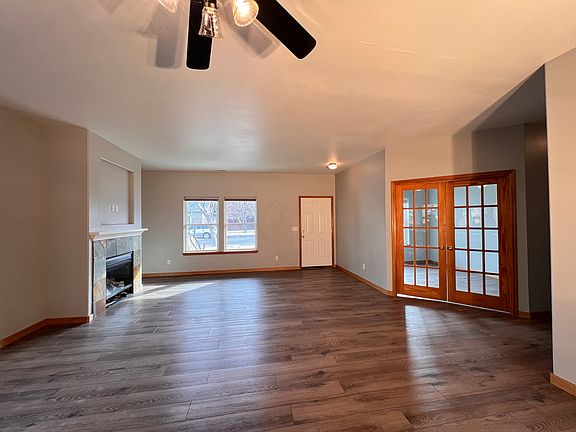 View of the front door, gas fireplace and office / den french doors from the kitchen. Floors are brand new throughout the home.