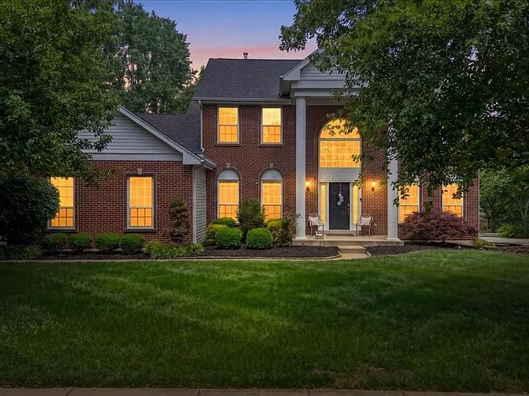 Traditional brick facade with white siding accents and a dark shingle roof