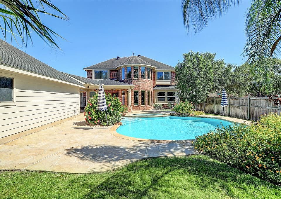 Welcome to your backyard oasis! Home has a large pool with spa, covered back patio and extended cool decking around the pool, mature palm trees and flowering bushes and trees, no side neighbors, and still plenty of yard space.