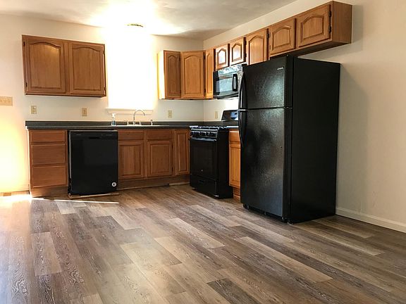 Kitchen with Oak cabinets, new black appliances, luxury vinyl flooring and tons of space