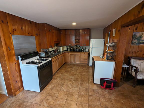 View of kitchen as you enter apartment. Dining room to the left and living room and staircase to the right. Small bathroom and laundry room off of kitchen.