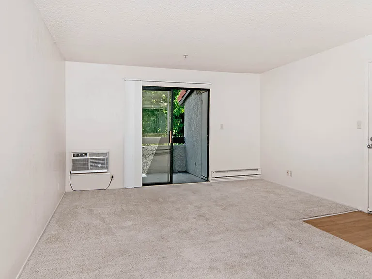 Carpeted Living Room with Balcony