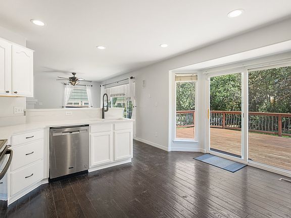 Kitchen with new quartz counter tops, sink, and faucet. Open flow into family/tv room.