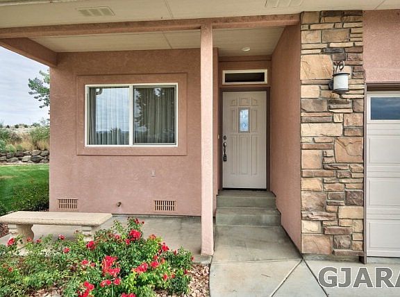Roses greet you at the entry to this extra-cute stucco-and-stone townhome locate