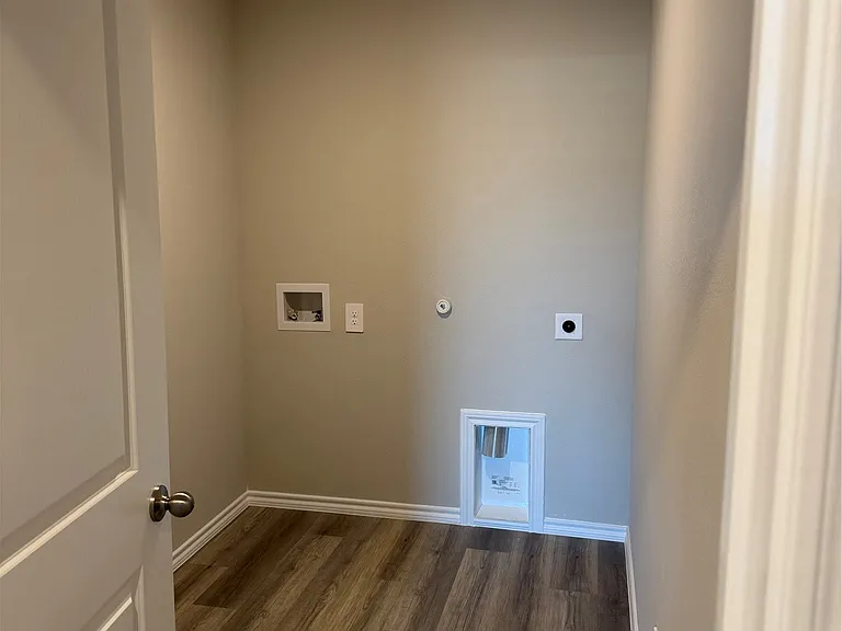 Dedicated utility space featuring durable wood-finish flooring, recessed lighting, and wall-mounted electrical outlets