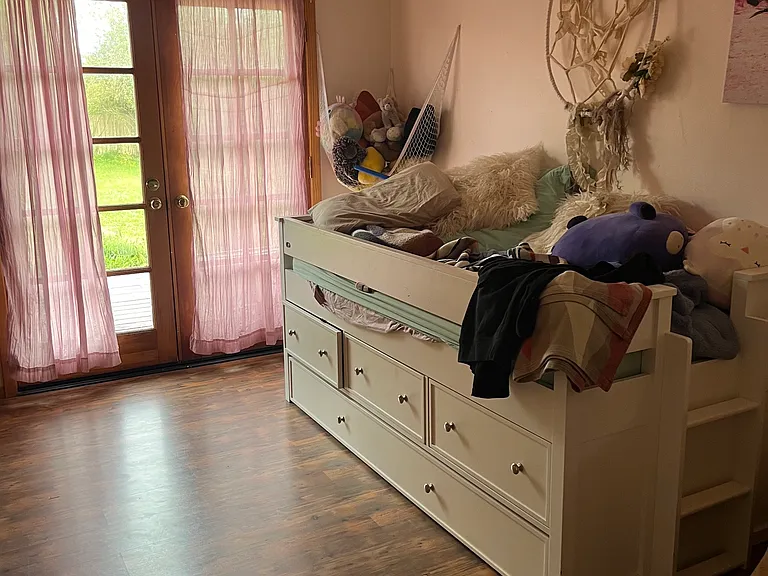 This is the second original bedroom, with French doors to the east and a medium sized closet with wooden sliding doors.