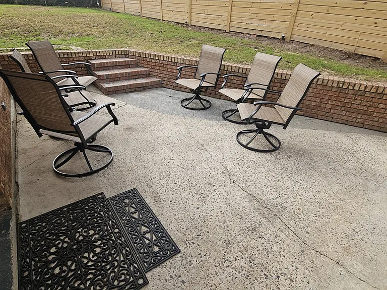 Patio - 6 swivel chairs creates a seamless indoor-outdoor entertaining area. Brick wall & stairs allow seating for 7 more people.