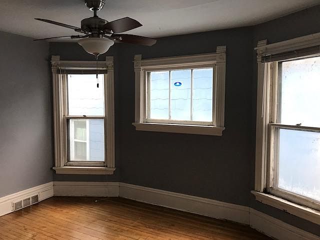 Bedroom with original trim and new windows.