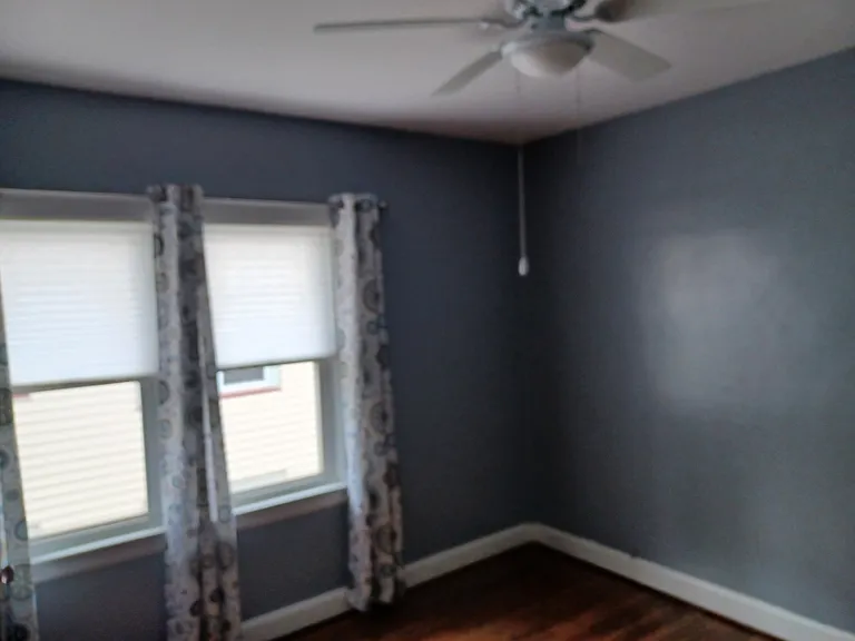 Bedroom 1 view 2 with newer windows and optional window treatments for tenant use.