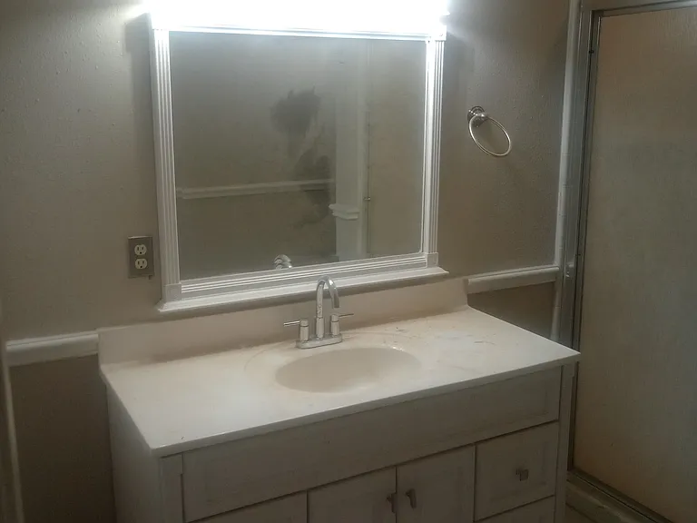 Guest bathroom (main bathroom) completely remodeled with tile, large single vanity, and walk-in shower.