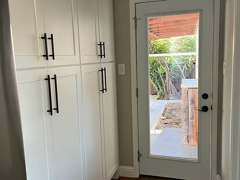 Pantry hall leading to back yard & half bath