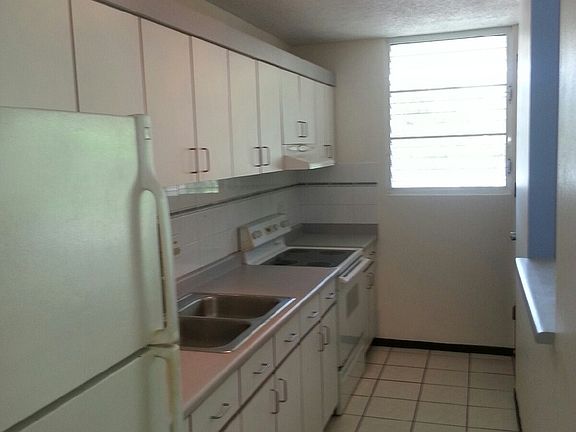 Kitchen space furnished with refrigerator and electric range