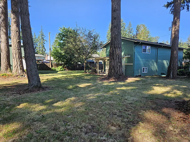 View of backyard from corner of fence looking SW