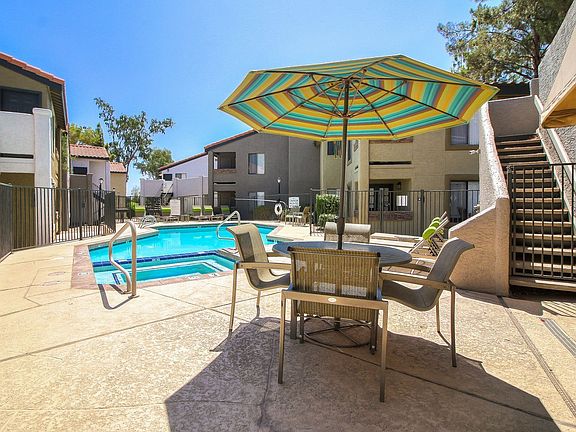 Courtyard pool and spa with long lounge chairs and umbrella-shaded picnic area.