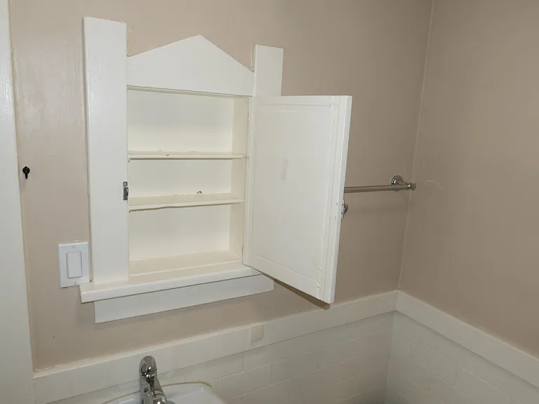 Bathroom medicine cabinet above pedestal sink.