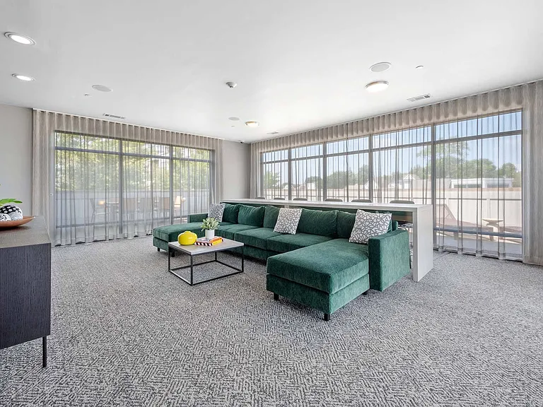Relax in the roomy lifestyle amenity center featuring comfy seating and a TV, perfect for unwinding or hanging out with friends.