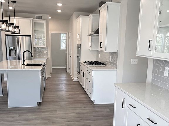 Island kitchen with white cabinets in a DRB Homes Colton II plan in the Barron Heights community.