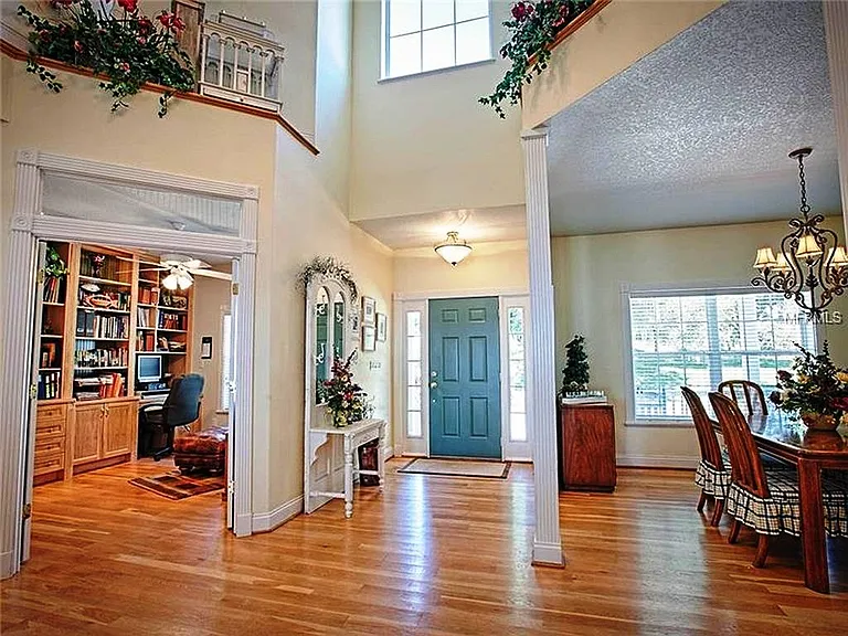 This is the two story foyer with the main entry door off the wrap around porch. The office is on the left and the dining room on the right. The upper BR and craft rooms have balconies that overlook the foyer, which looks out on the porch and lake beyond
