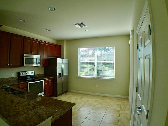Kitchen with granite countertops, stainless appliances, and slider access to the lanai