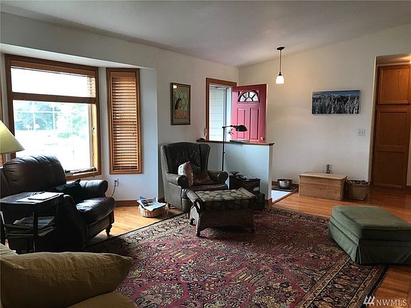 Living room has oak floors, bay window facing south with wooden blinds.  Wood wrapped windows and doors.