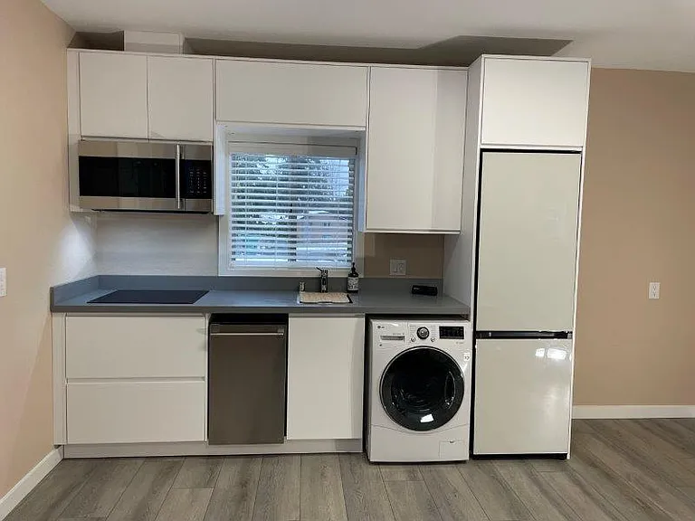 New kitchen, contains new cabinets, granite counter, stove top, microwave/convection oven, dishwasher, washing machine/dryer combo, and fridge/freezer.
