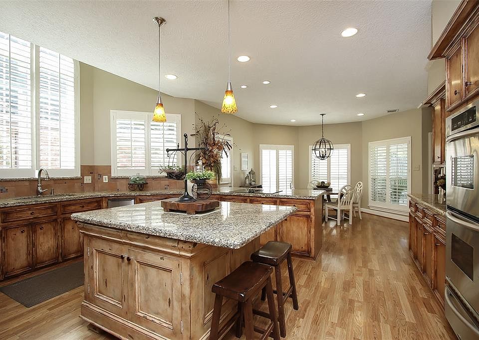 This view of amazing kitchen towards breakfast area. It was a complete major remodel coordinated by a professional design firm. The entire area was freshly painted recently. Cabinetry finish was richly distressed and antiqued. Spacious amount and are