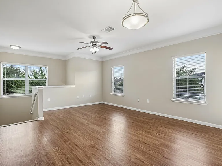 Bright and spacious living room with elegant light fixtures and wood-style flooring, featuring large windows for natural light. Bright and spacious living room with elegant light fixtures and wood-style flooring, featuring large windows for natural light.