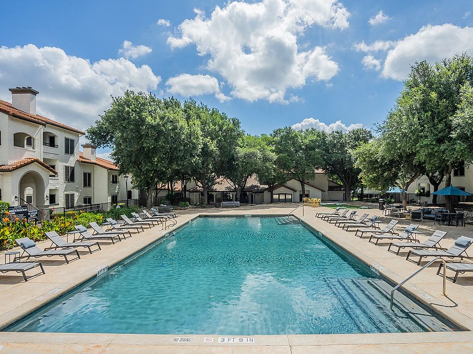 Large Community Pool with Poolside Seating and Adjacent Tree-Lined Walkway
