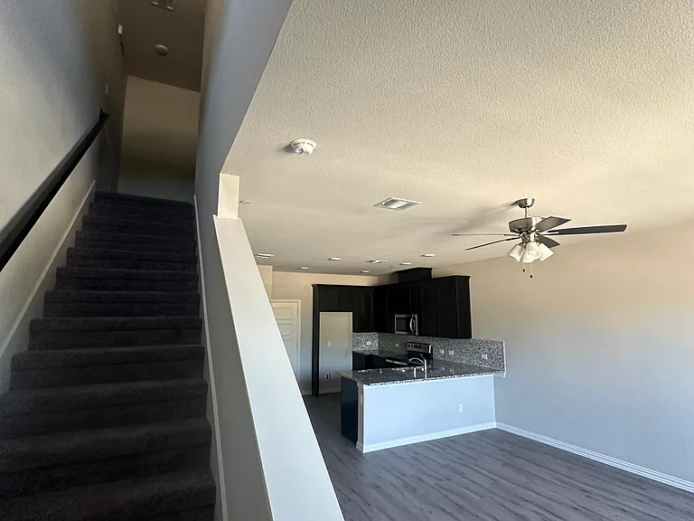 Spacious down-stairs living, dinning, and kitchen area with large window letting in morning light.