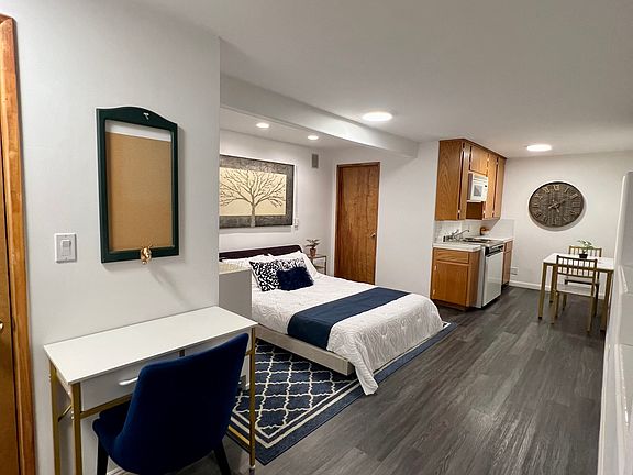 Main living area with queen size bed, kitchenette, and working desk.