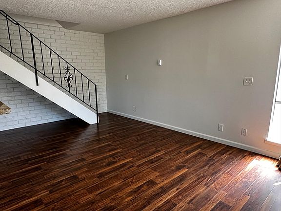 Stairs with brick accent wall from living area to 2nd floor