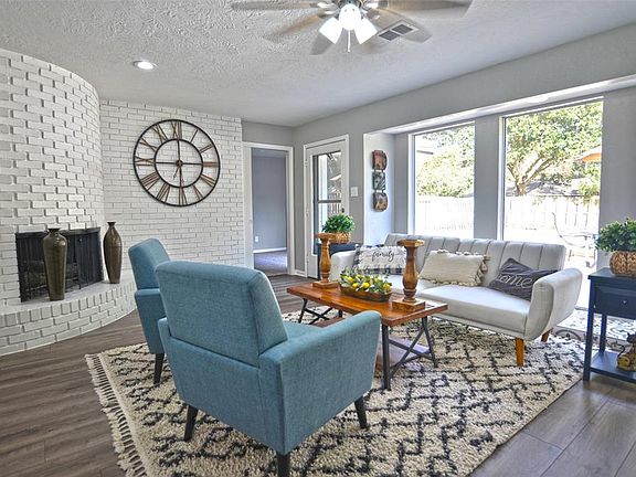Family Room with fireplace and floor-to-ceiling windows overlooking pool & yard