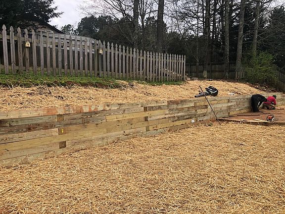 new retaining wall in backyard - does NOT show the wood stairs in place leading to upper level (grass will come in in the next few weeks)