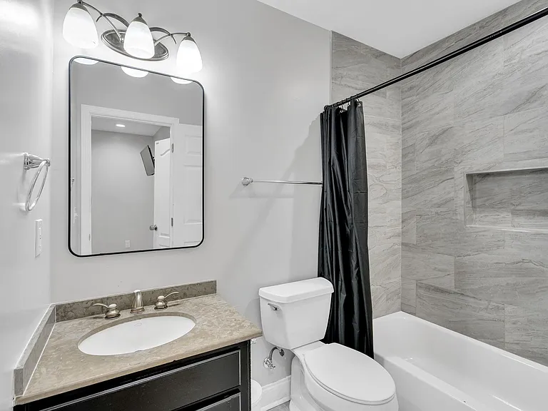 Modern full bathroom featuring a sleek vanity, clean toilet, and stylish tub/toilet combo for your comfort and convenience!
