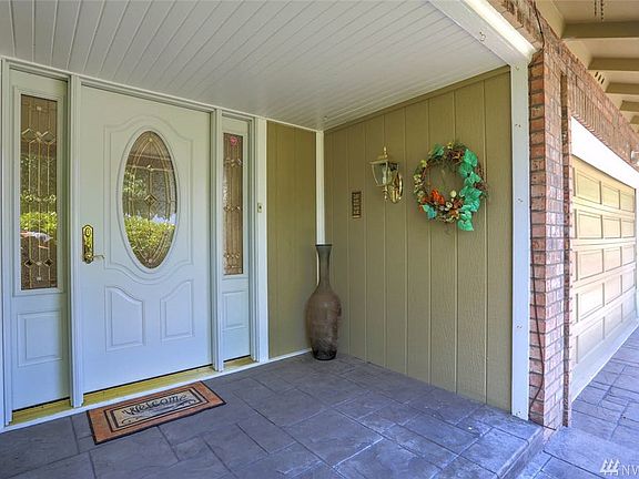 The charming covered porch and stunning stamped concrete welcomes guests in.